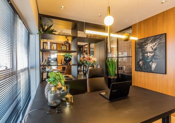 Home office com marcenaria escura e iluminação em pendente